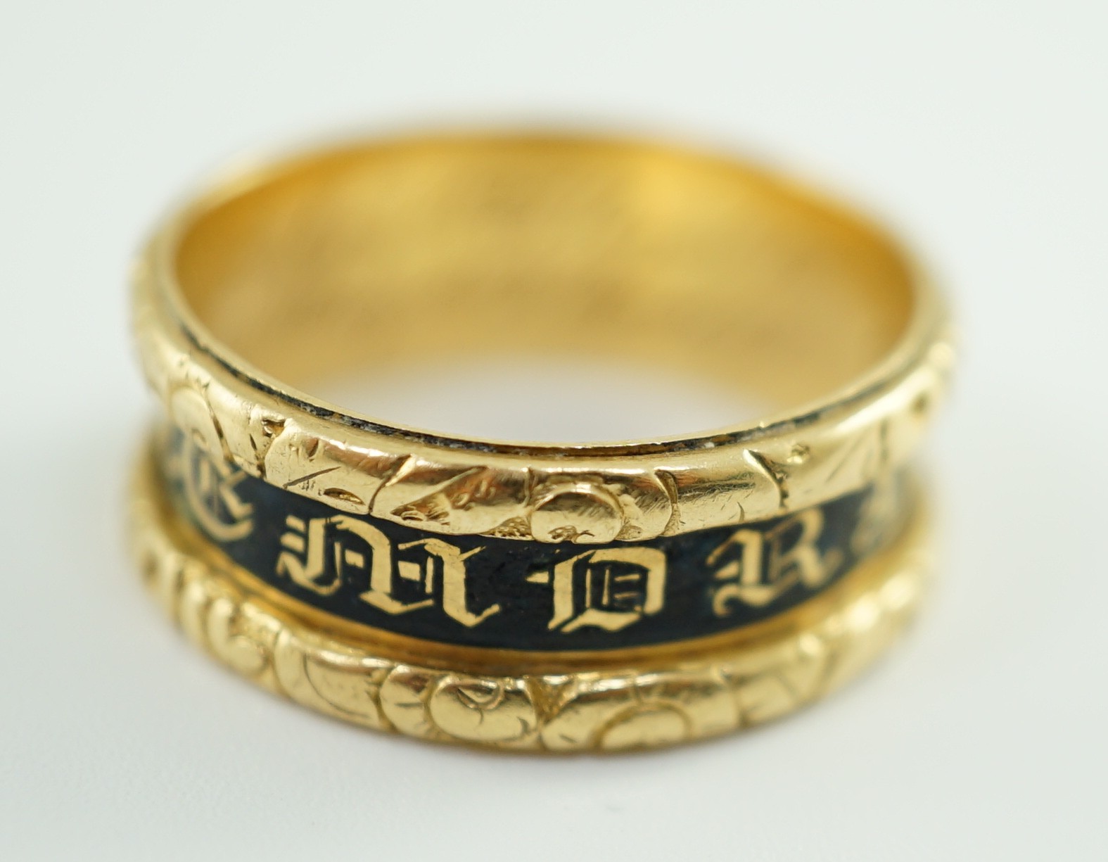 A George IV 18ct gold and black enamel 'In Memory Of' mourning band, with carved scroll border